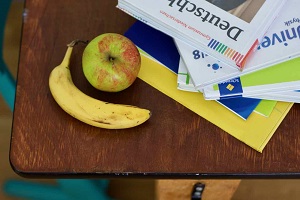 © Vesch NI | Schreibtisch mit Schulmaterial, Apfel, Banane